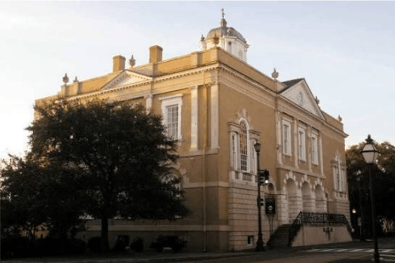 Exterior facade of the historic Old Exchange and Provost Dungeon building at sunset in Charleston, South Carolina.
